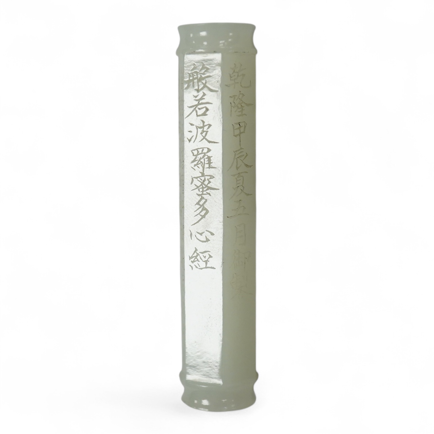 A Chinese pale celadon jade inscribed cylinder bead, 6.5cm long